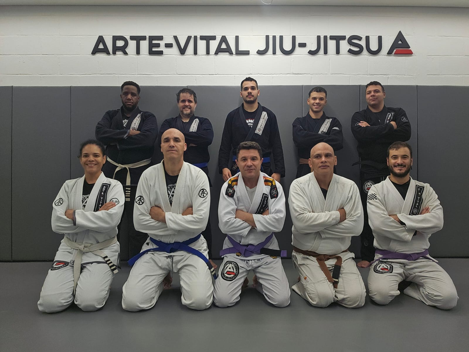 Alunos e instrutores em frente ao logo