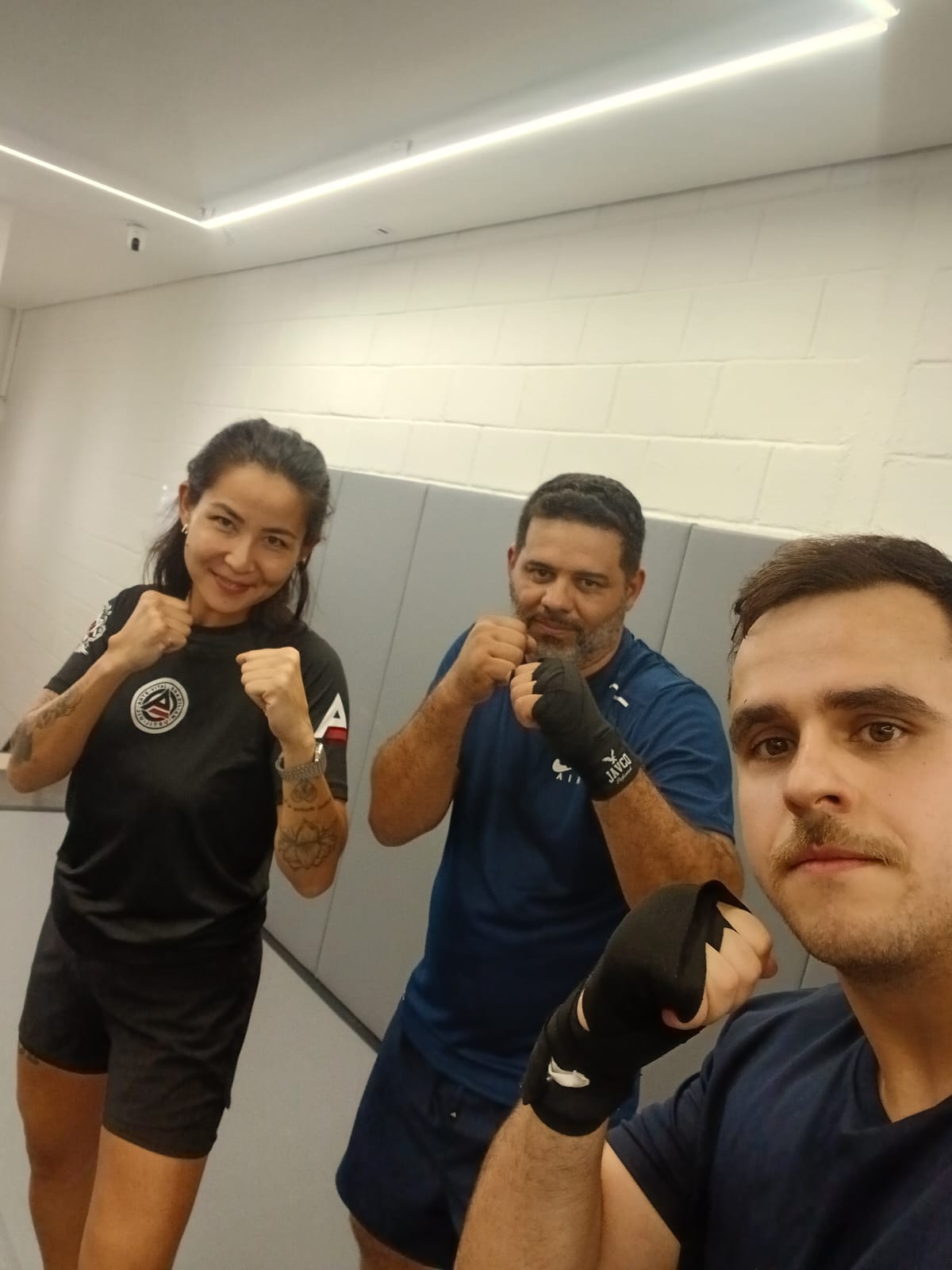Turma de Boxe da Arte Vital em frente ao logo da academia